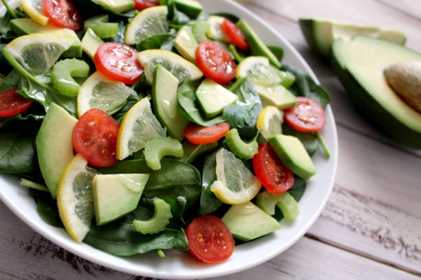 istock Avocado salad with vegetables on a wooden background. 945282376