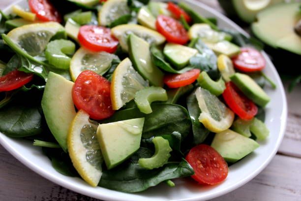 istock Avocado salad with vegetables on a wooden background. 945282682