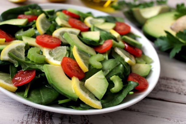 istock Avocado salad with vegetables on a wooden background. 945282804
