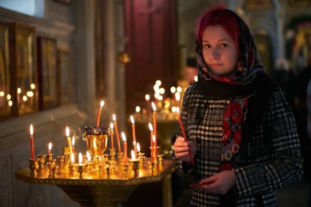 istock Praying young woman with candle 945286568