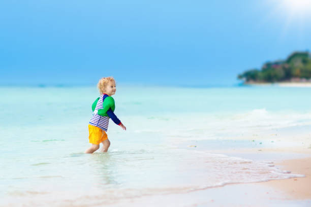istock Kids play on tropical beach. Sand and water toy. 945289022