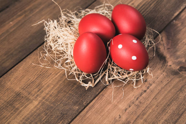 istock Red easter eggs in nest on wooden background 945293570