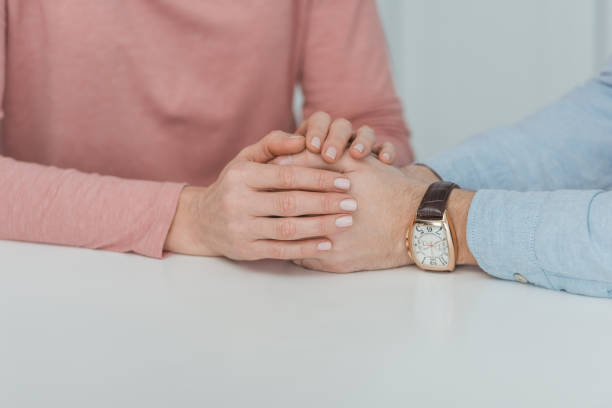 istock partial view of mother and grown son holding hands while sitting at table 945297132