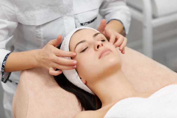 istock Beautician doing face massage to beautiful brunette 945300654