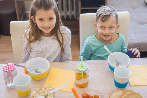 istock Portrait brother and sister having breakfast together 945300962