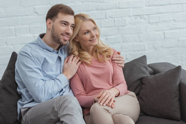 istock portrait of smiling son hugging mother while resting on sofa at home 945301016