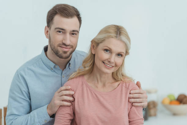 istock portrait of grown son hugging smiling mother 945309088