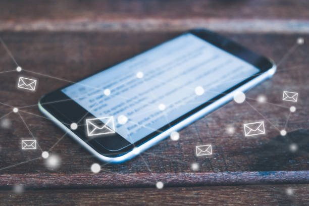 istock smartphone on desk with letter icons . email / mail concept on mobile phone 945309168