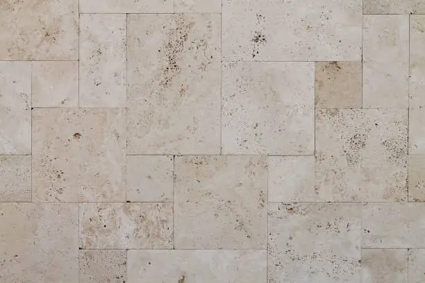 Natural Italian stone. Smooth travertine surface. A sample of wall cladding with natural stone.