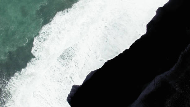 istock Water, foam and black sand 945316008