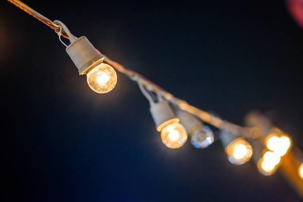 istock string wired with warming light Bulbs hanging in the area of events Celebration in the night 945333214