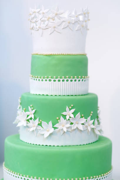 istock Green wedding cake decorated with white flowers 945343870