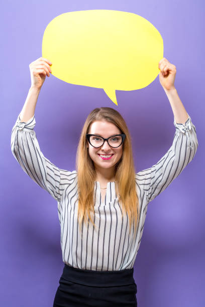 istock Young woman holding a speech bubble 945344062