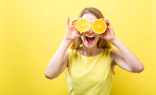 istock Happy young woman holding oranges 945344076