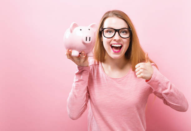istock Young woman with a piggy bank 945344190
