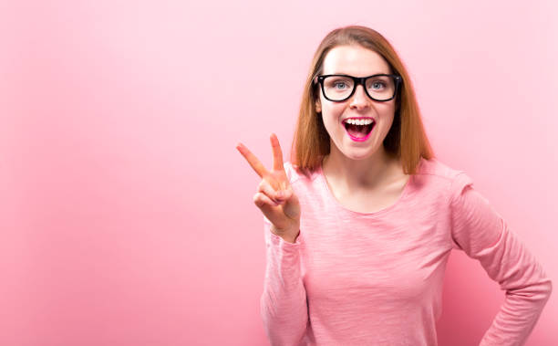 istock Young woman giving the peace sign 945344266