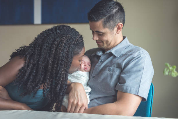 istock New parents snuggle with their newborn daughter 945344644
