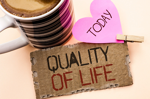 Text sign showing Quality Of Life. Conceptual photo Good Lifestyle Happiness Enjoyable Moments Well-being written Tear Cardboard Piece the plain background Pink Heart and Coffee Cup.