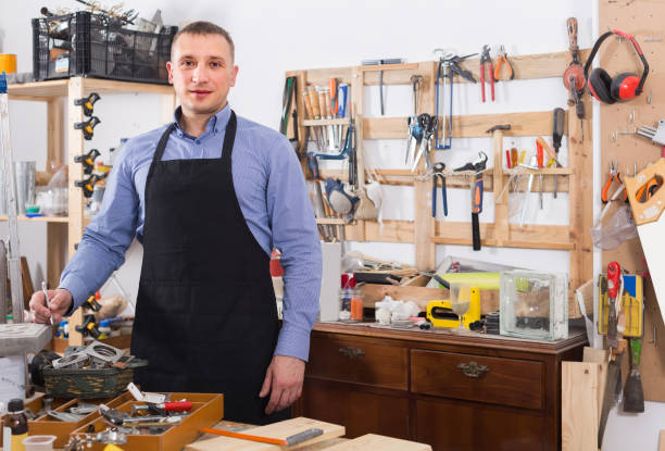 istock Portrait of young handsome carpenter in uniform in workshop. 945354156