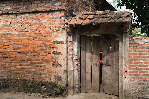 Old aged house entrance and wall made of laterite in Duong Lam ancient village, Son Tay district, Hanoi,  Vietnam