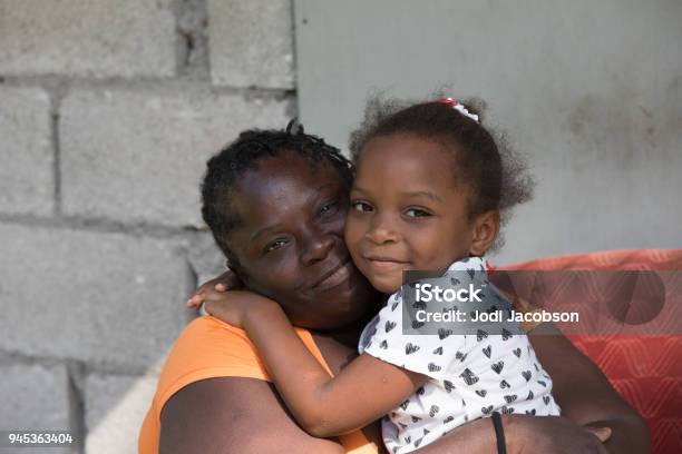 Portrait Of A Jamaican Mother From A Remote Village Hugging Her Young Daughter Stock Photo - Download Image Now