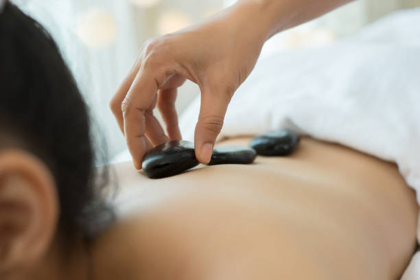 istock Young beautiful woman getting hot stone spa treatment.