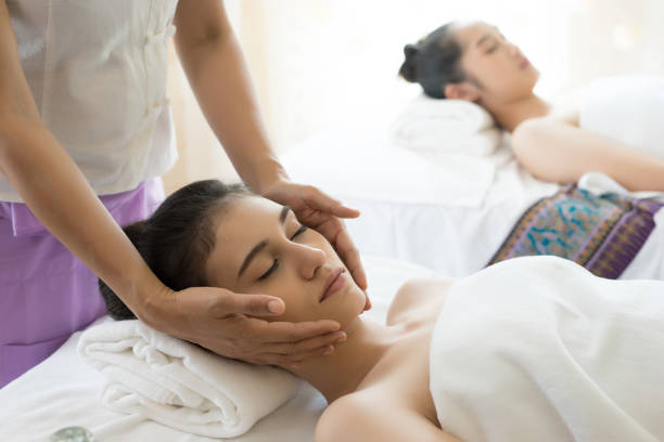 istock Young beautiful woman having face massage relaxing in spa. 945374480