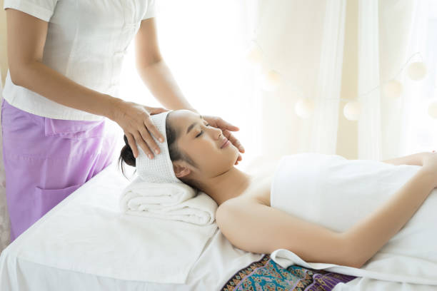 istock Young beautiful woman having face massage relaxing in spa. 945374504