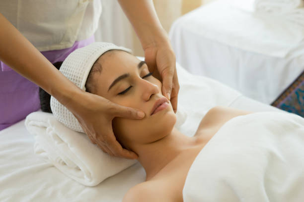 istock Young beautiful woman having face massage relaxing in spa. 945374538