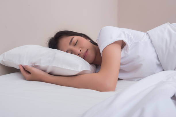 istock Young woman sleeping in her bed. 945380854