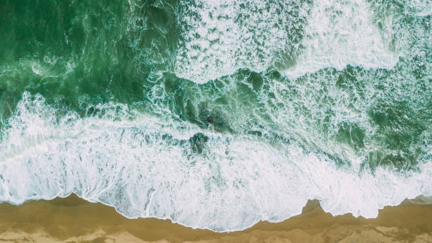 istock Waves near beach. Yellow sand and green water 945381438