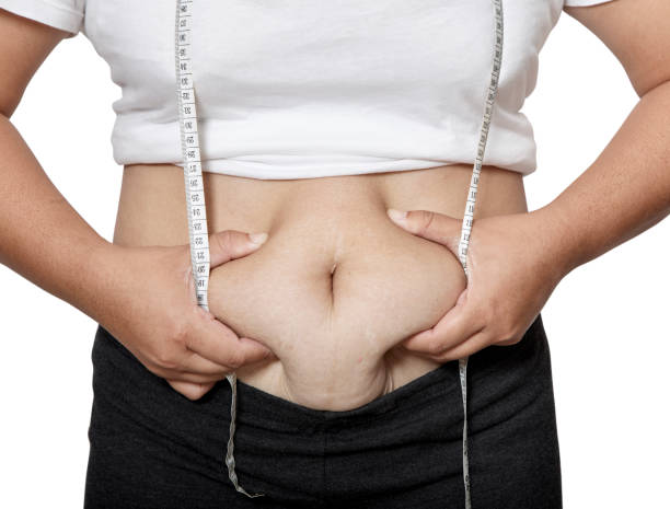 istock Asian woman with fat holds belly. 945384390