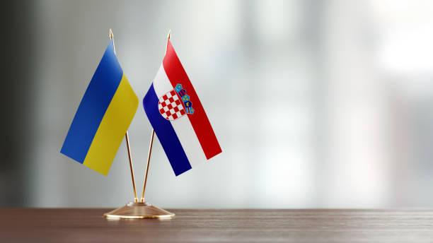 istock Ukrainian And Croatian Flag Pair On A Desk Over Defocused Background 945387310