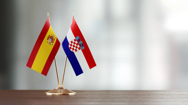 istock Spanish And Croatian Flag Pair On A Desk Over Defocused Background 945387416