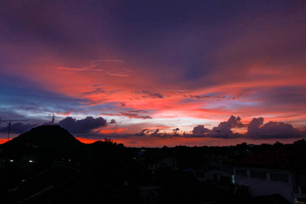 istock Colorful twilight cloudy sky at the sunset background with mountain and tree silhouette background 945391828