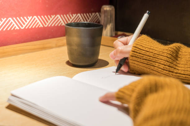 istock women writing a book on wooden table, blank book for copy space, education concept 945404906