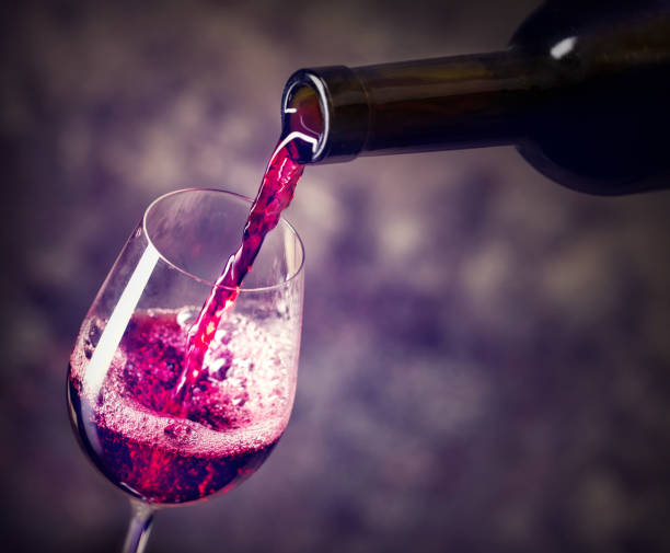 istock Red wine is the being poured into glass 945409364