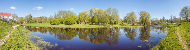 istock Trees of the park with reflection in the river in Pskov 945412138