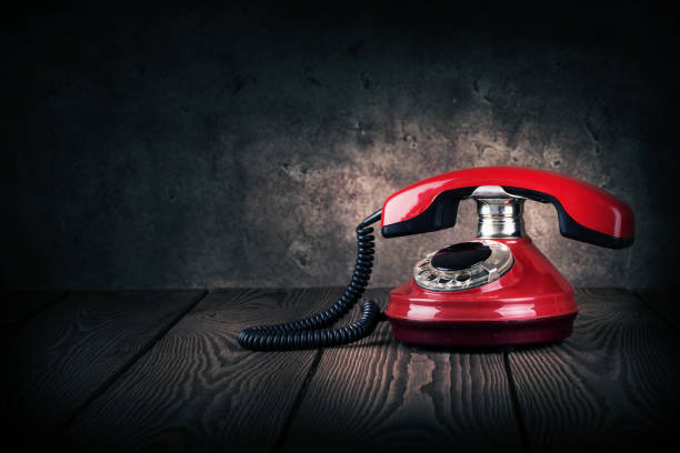 istock Old red phone on a wooden table 945412970