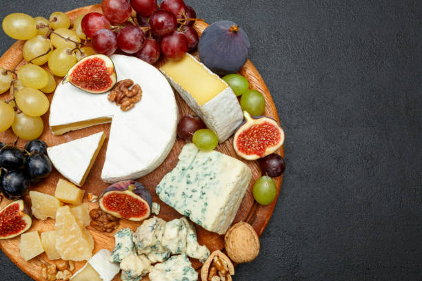 istock Brie cheese on a wooden Board with fresh figs and grapes 945420544
