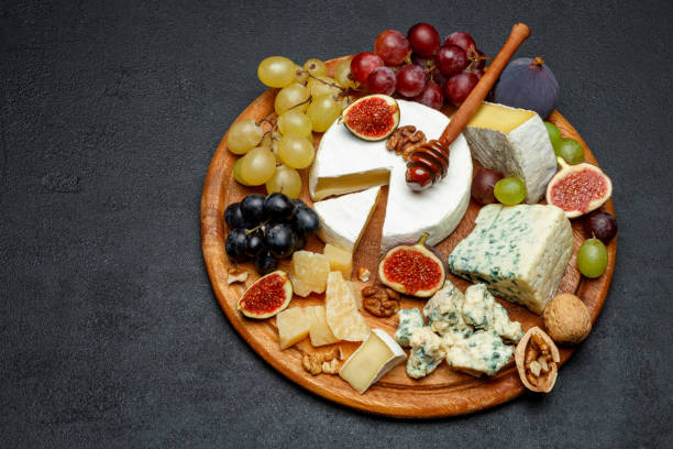 istock Brie cheese on a wooden Board with fresh figs and grapes 945420630