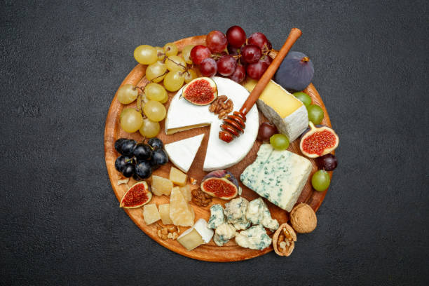 istock Brie cheese on a wooden Board with fresh figs and grapes 945420658