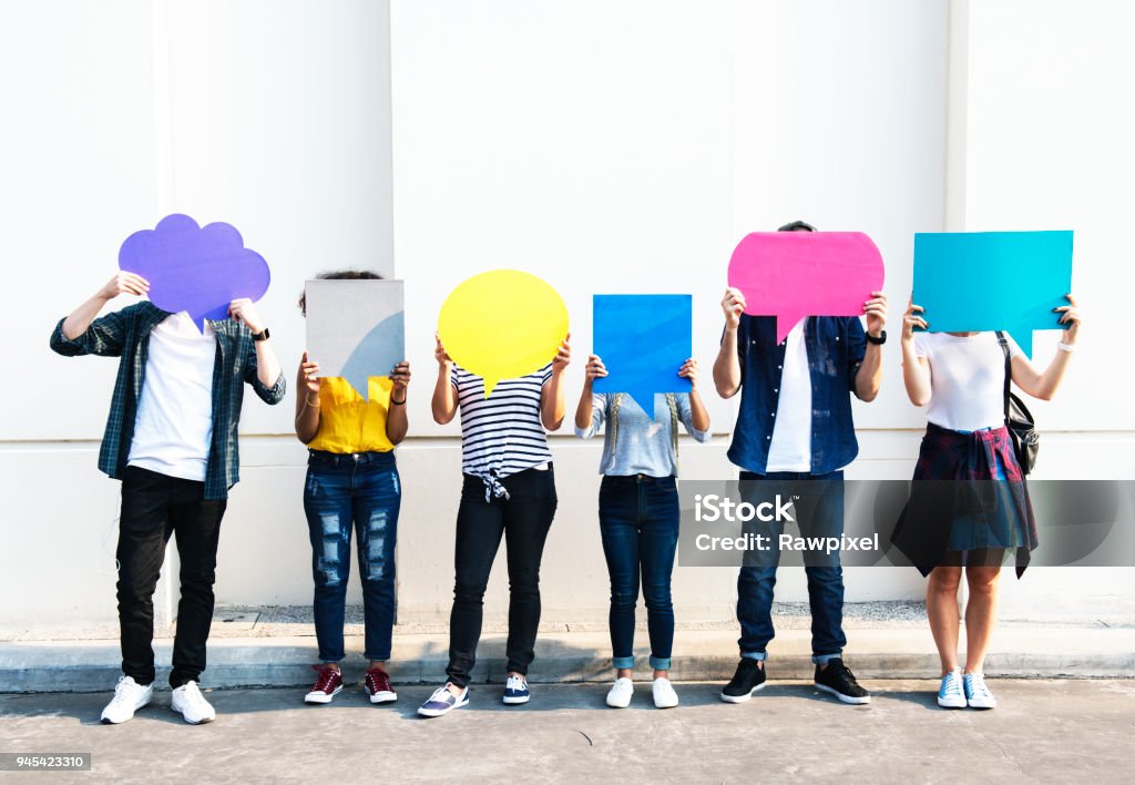 Young adult friends holding up copy space placard thought bubbles Teenager Stock Photo