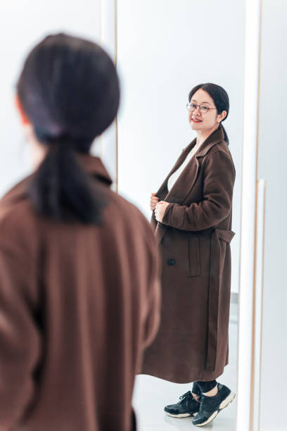 istock Beautiful woman dressed in front of mirror 945425004