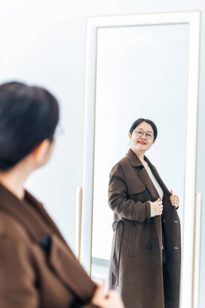 istock Beautiful woman dressed in front of mirror 945427312