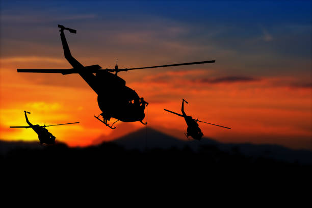 istock soldier silhouette in rappelling climb down from helicopter on sunset with copy space add text ( Concept stop hostilities To peace) 945428122