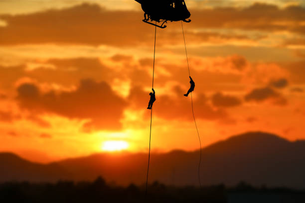 soldier silhouette in rappelling climb down from helicopter on sunset with copy space add text ( Concept stop hostilities To peace)