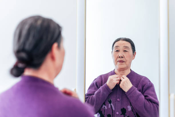 Senior woman dressed in front of mirror