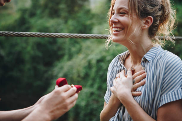 Man proposing to his woman with a red box Man proposing to his woman with a red box ring jewelry photos stock pictures, royalty-free photos & images