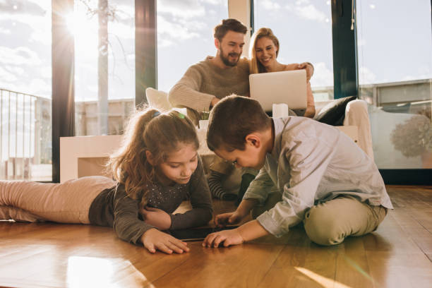 istock Happy family using wireless technology while relaxing at home. 945435756